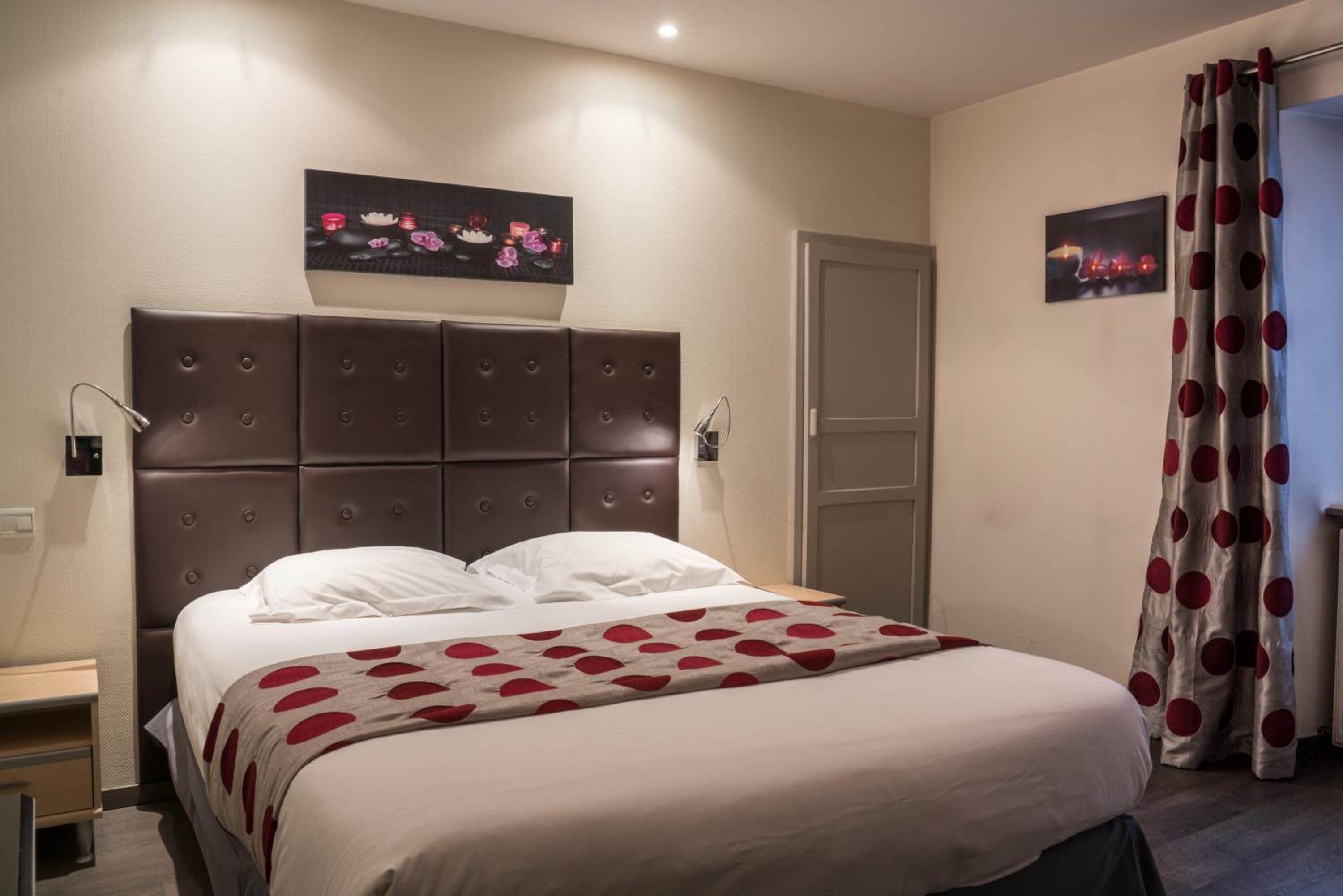 Ein Schlafzimmer mit einem großen Bett, einem Kopfteil, einem Nachttisch, einer Lampe und einer Tür.