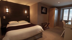 Ein Schlafzimmer mit einem Bett, einem Schreibtisch und einem Stuhl.