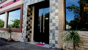 A building with a geometric facade, large windows, and a door with a pink mat. - Mandala Hotel (Encarnacion)