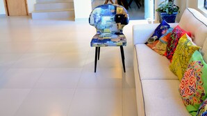 A hotel lobby with a staircase, a sofa with colorful cushions, and a fire extinguisher on the wall. - Mandala Hotel (Encarnacion)