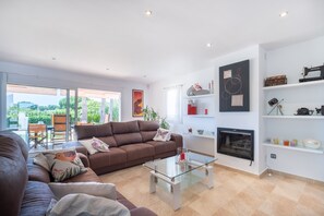 Una sala moderna con un sofá marrón, una mesa de centro de vidrio y una chimenea.