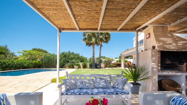 Un espace extérieur aménagé, abrité et doté d’une piscine, d’un barbecue et offrant une vue sur la verdure environnante.