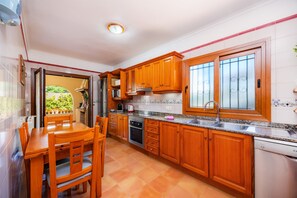 A kitchen with wooden cabinets, a granite countertop, a built-in oven, and a dishwasher.