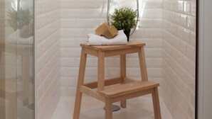 A shower with a glass door, a wooden stool, and a potted plant. - Il etait une fois chez moi Eugénie (Le Loroux-Bottereau)