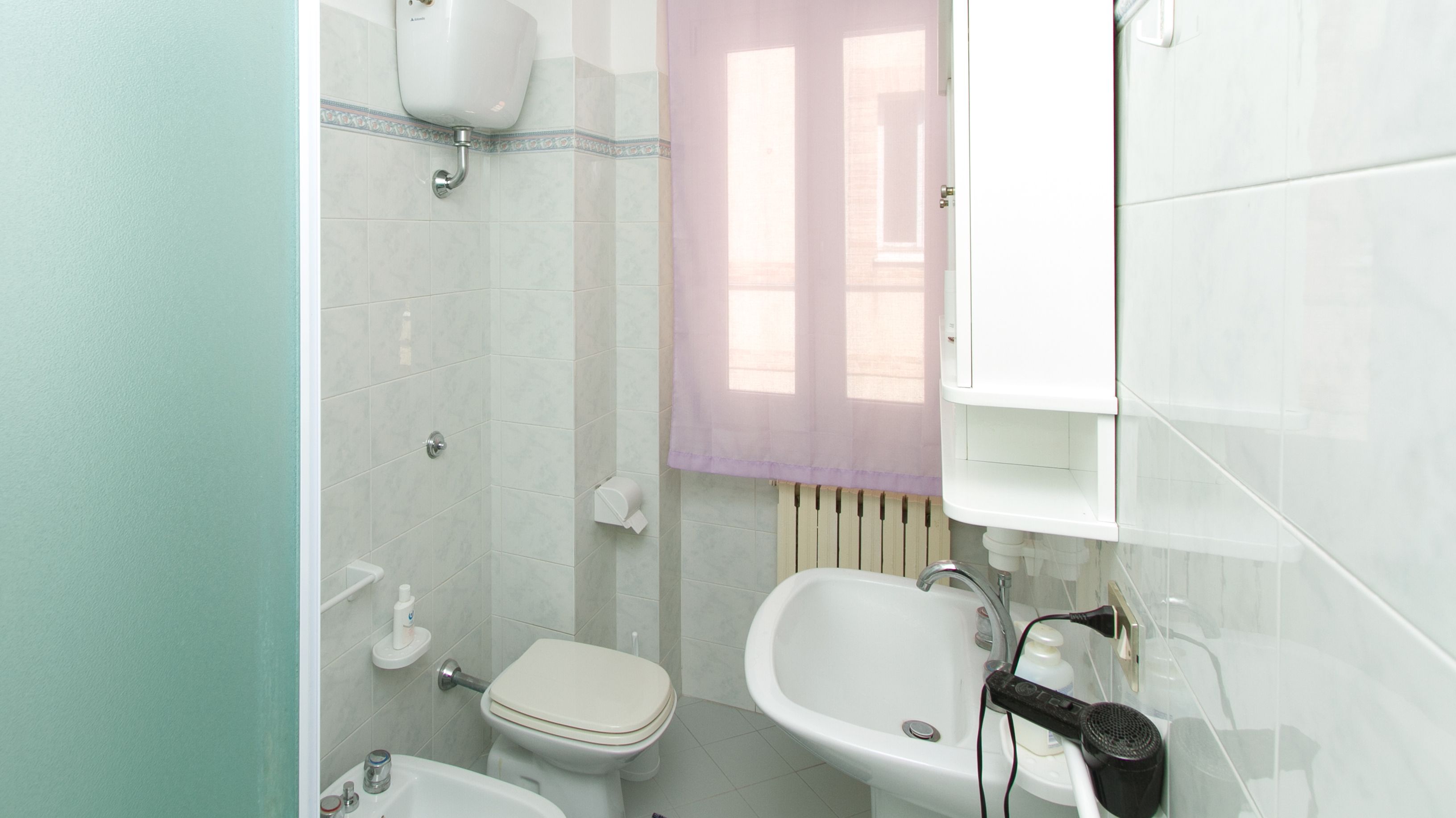 Un baño con inodoro, lavamanos y ducha.