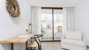 A modern living room with a wooden desk, a white sofa, and a large window with curtains. - Sa Clau by Mambo (Sant Antoni de Portmany)