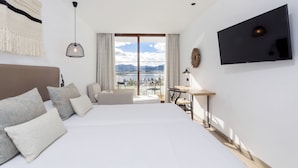 A modern hotel room with a large bed, a desk, and a TV. - Sa Clau by Mambo (Sant Antoni de Portmany)