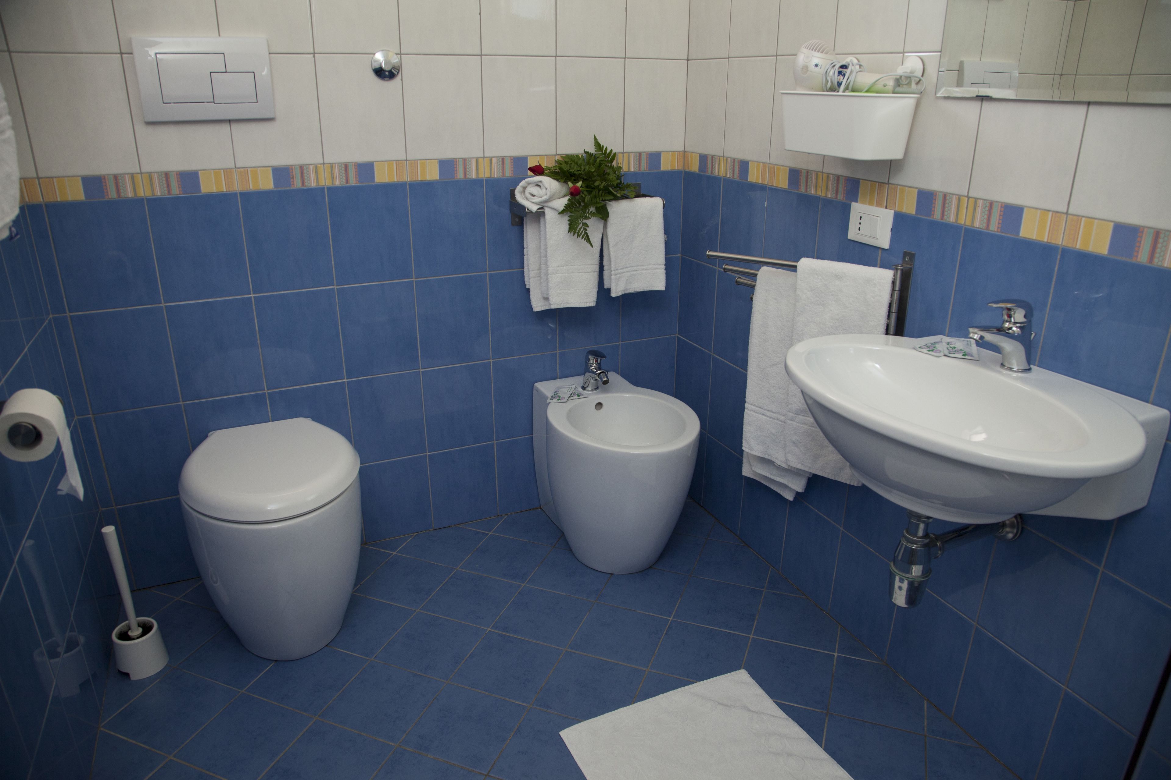 A bathroom with a toilet, bidet, and sink.