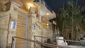 Un bâtiment doté d’un escalier en colimaçon, de murs en pierre et d’une enseigne indiquant « BAIA ».