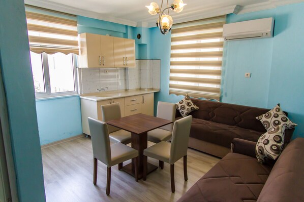 Um espaço compacto com cozinha compacta, sala de jantar e área de estar.