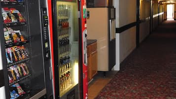 A hallway with vending machines and a refrigerator.