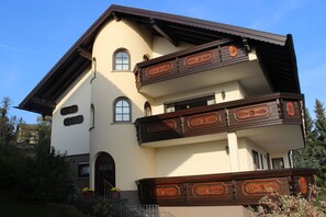 Um edifício de dois andares com varanda e porta.