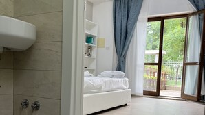 A modern bathroom with a white sink, two faucets, and a shower area. - B&B Santa Maria Apparente (Civitanova Marche)