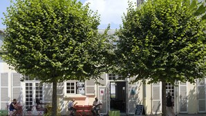 A building with a cafe area featuring outdoor seating. - Hostel La Maison Montreau (Montreuil)