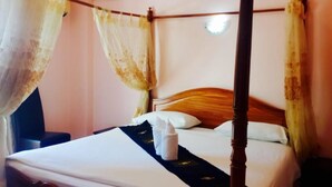 Un letto a baldacchino con lenzuola bianche e una coperta nera.