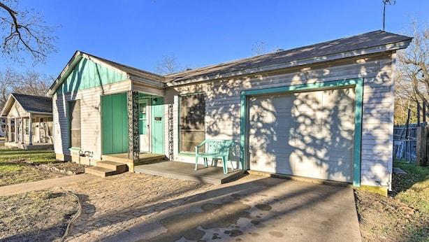 A single-story house with a front porch, a garage, and a small patio area with a bench. - Home 2 Mi to Dtwn Temple! Bring Your Pets (Temple)