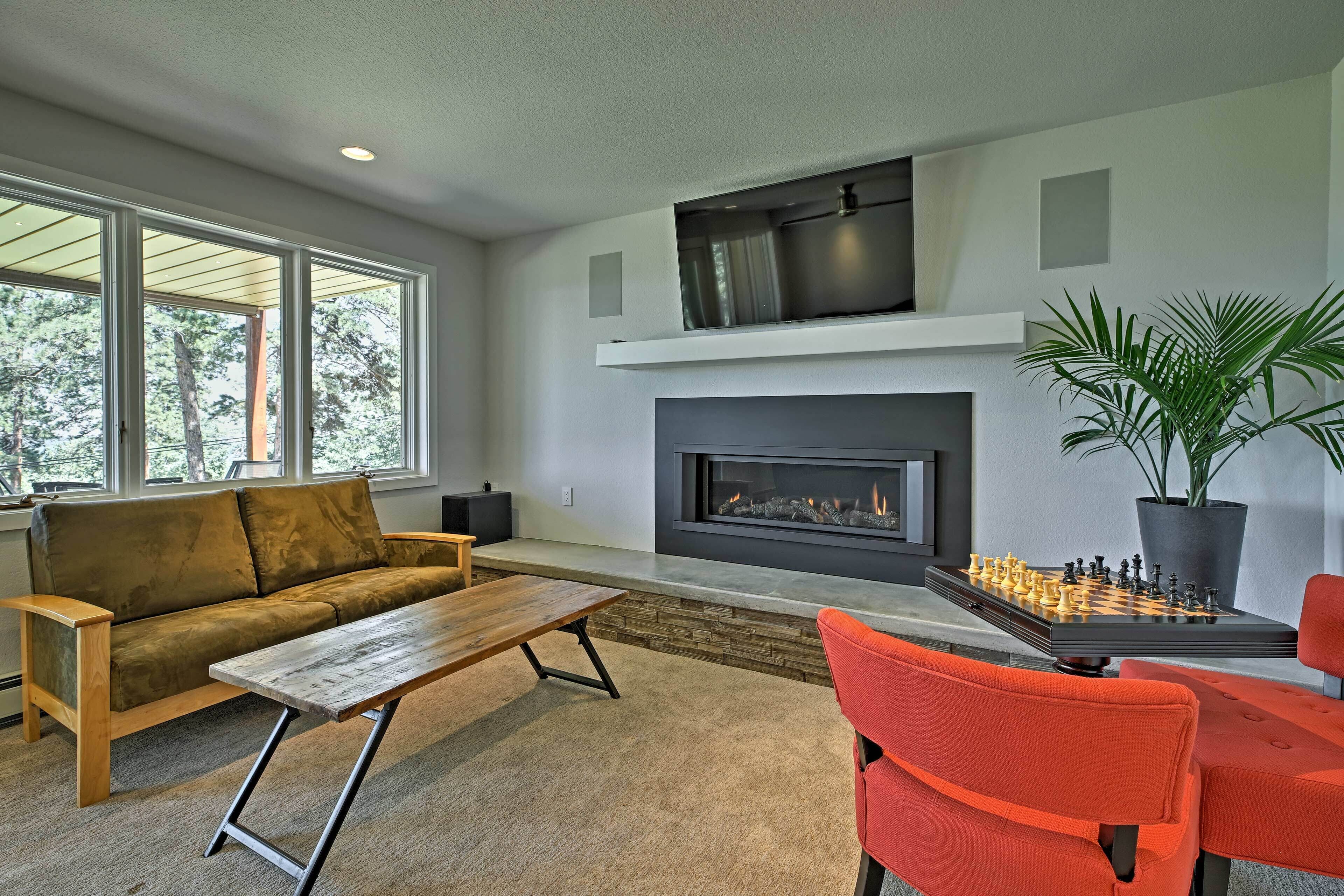 A modern living room with a fireplace, a sofa, a coffee table, and a chessboard.