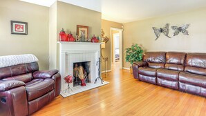 A living room with two leather sofas, a fireplace, and decorative items. - 5 Mi to Dtwn ATL! Family Home w/ Veranda & Yard (Atlanta)