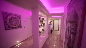 A hallway with a marble floor, a glass display case with decorative items, and a large painting on the right wall. - Tropea Luxury & Charm (Tropea)