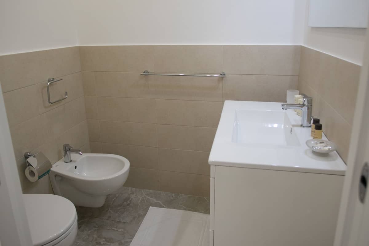 A small bathroom with a toilet, bidet, and sink.