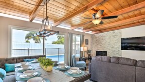 A dining area with a wooden ceiling, a large window, and a view of the ocean. - Chic Central San Diego House w/ Private Pool! (San Diego)