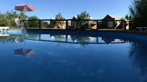 A swimming pool with a clear blue tiled surface, a ladder, and an American flag. - El Descanso (Colon)