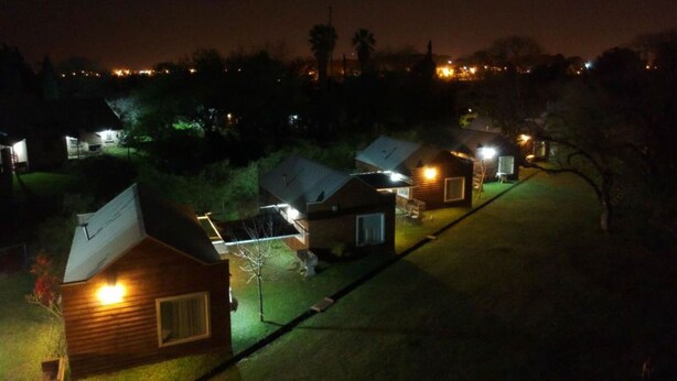 A row of small, single-story cabins with sloped roofs, each illuminated by a single light source, likely indicating a residential or vacation setting. - El Descanso (Colon)