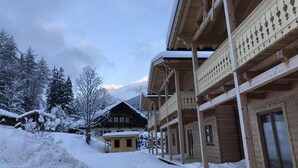 Un chalet en bois doté d’un balcon, avec un paysage enneigé.