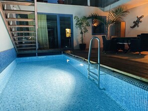 A swimming pool with a metal ladder, surrounded by a wooden deck and potted plants. - Large bungalow w/private pool, few min. from the sea, protected inner courtyard. (Kanarische Inseln)