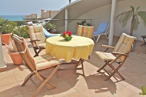 A terrace with a round table and six chairs, a view of the sea, and potted plants. - Large bungalow w/private pool, few min. from the sea, protected inner courtyard. (Kanarische Inseln)