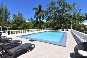 A swimming pool with lounge chairs and a white fence. - Comfy bedrooms with swimming pool plus free wifi, spa hut, bbq, 24-hour security (Ohco Rios)