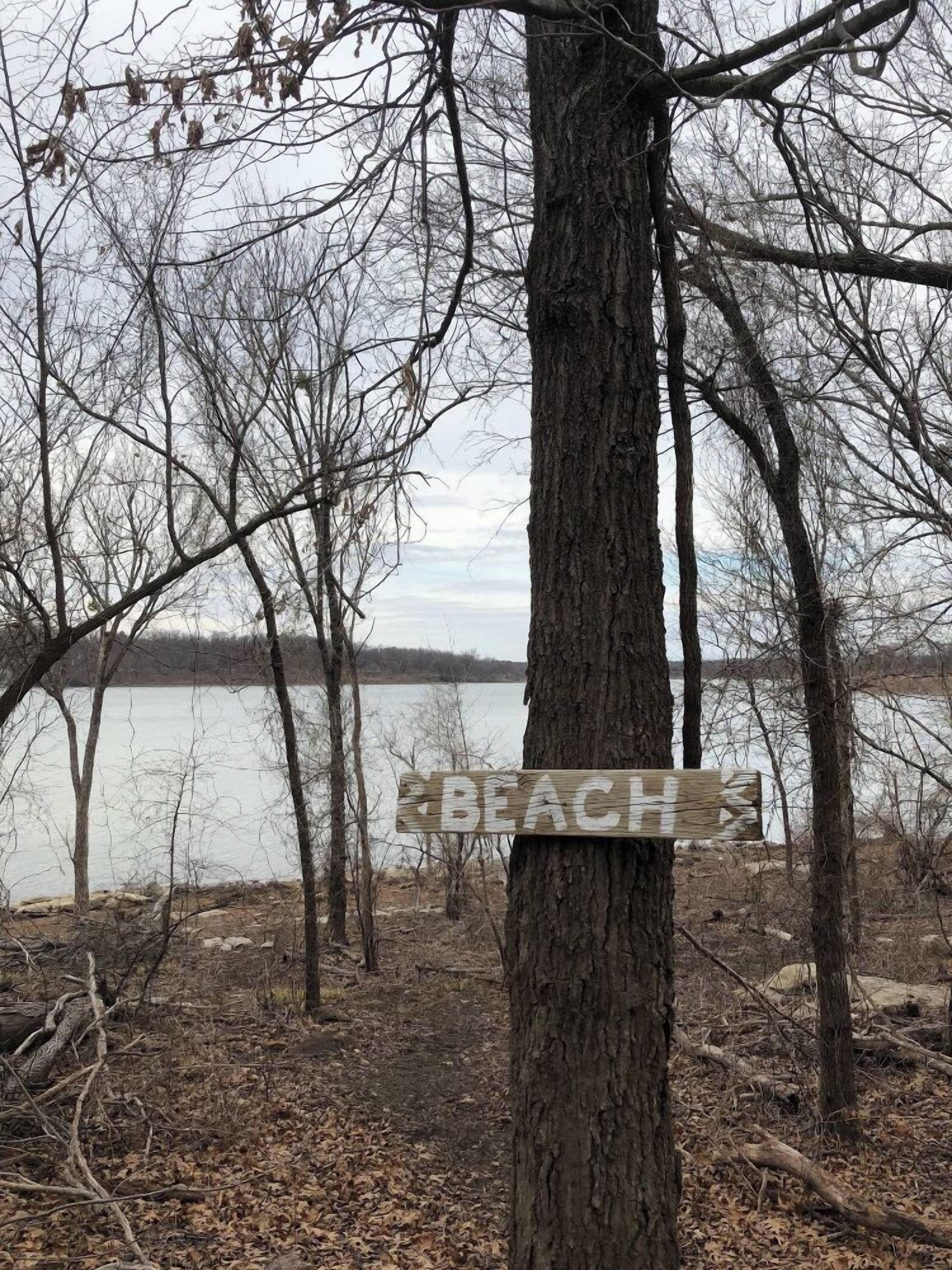 Eine natürliche Umgebung mit einem Schild, das einen Strand anzeigt.