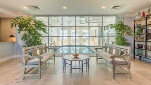 Una habitación amplia con un gran ventanal, una mesa redonda y dos bancos de madera.