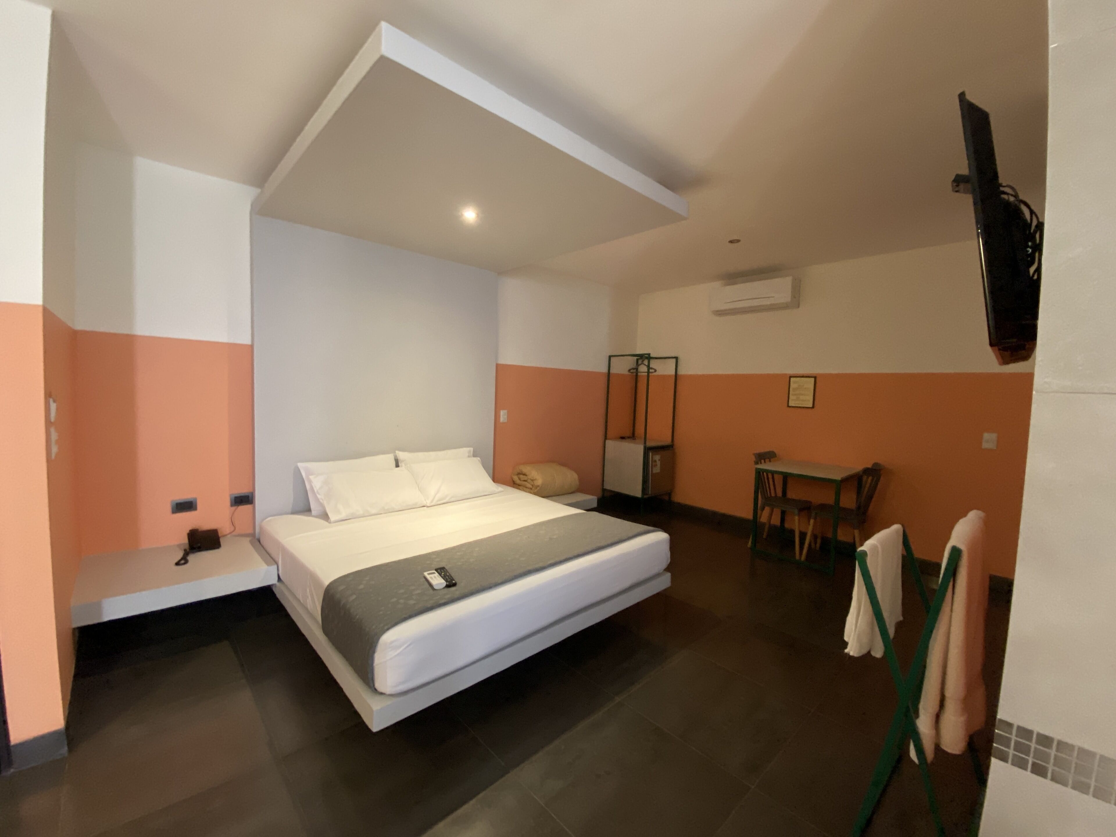 Habitació d'hotel moderna amb un llit, un escriptori i una cadira.