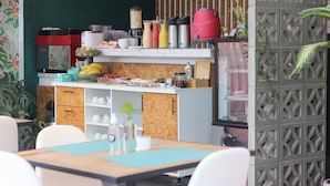 Een moderne keuken met een houten aanrecht, diverse apparaten en een eethoek met stoelen en een tafel.