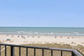 A beach with a wooden fence, a clear sky, and the ocean. - Oceanfront in Heart of N Myrtle  Beach with Pool (North Myrtle Beach)