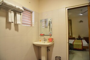 A bathroom with a sink, mirror, towel rack, and a window with blinds. - Pai Vista, KR Road, Bangalore (Bengaluru)