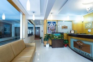 A reception area with a reception desk, a poster, a fish tank, and a seating area.