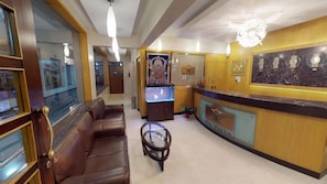 A reception area with a reception desk, a sofa, and a small table. - Pai Vista, KR Road, Bangalore (Bengaluru)