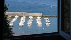 Een jachthaven met afgemeerde boten en zeilboten op het water.