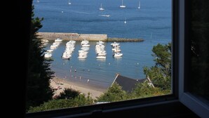 Een uitzicht op een jachthaven met afgemeerde boten en een strand op de voorgrond.