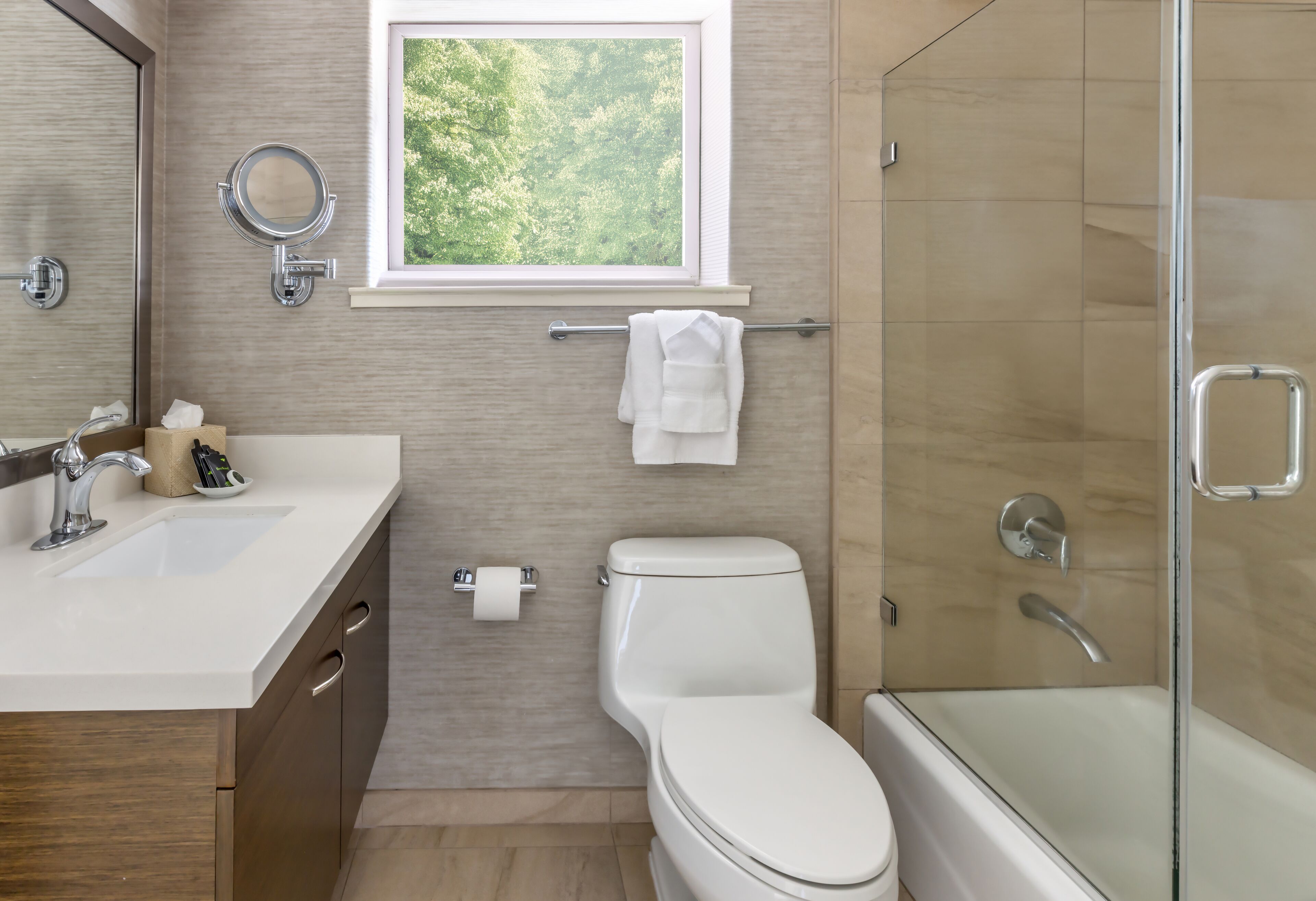 A modern bathroom with a toilet, sink, and shower.