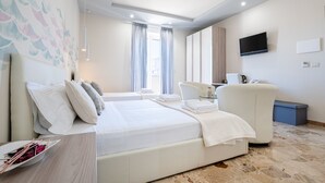 Una habitación de hotel con una cama grande, un sofá, un televisor y un escritorio con lámpara.