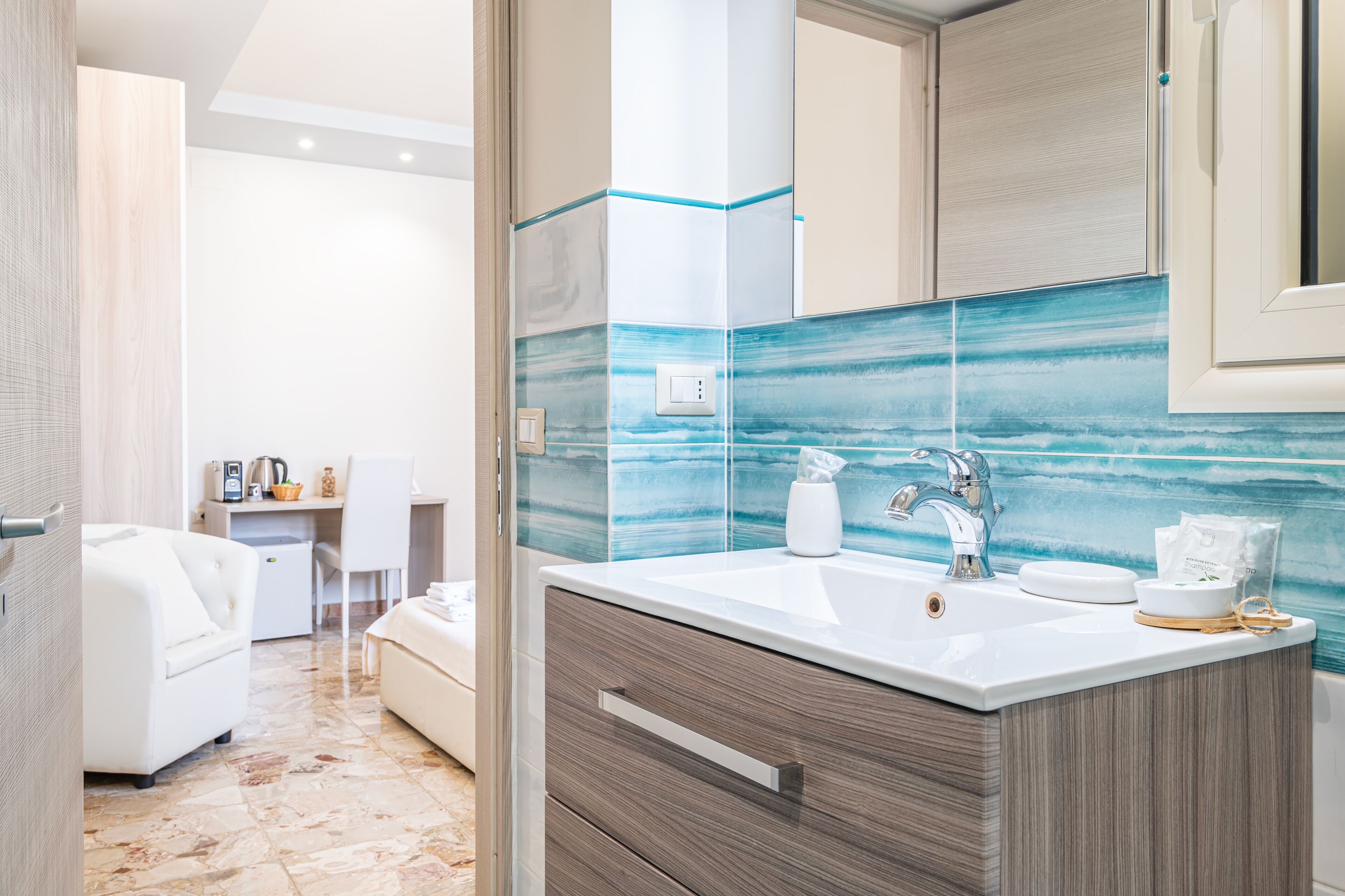 Un baño moderno con un espejo grande, un lavabo blanco y un salpicadero de azulejos.