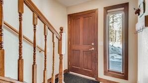 A wooden staircase with a carpeted landing leading to a wooden door. - Pinecreek #F - 3 BR: Close to Town- Shuttle to Slopes- Pool & Hot Tub Access (Breckenridge)