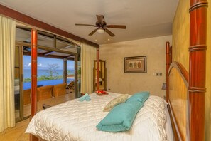 Ein Schlafzimmer mit Bett, Deckenventilator und Meerblick.
