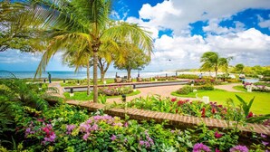 A tropical resort with a landscaped garden, palm trees, and a view of the ocean. - Casa Alegre, gorgeous villa in Rancho Santana! (Rancho Santana)