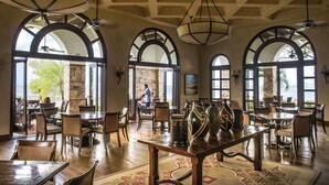 A spacious dining area with high ceilings, arched windows, and a view of the sea. - Casa Alegre, gorgeous villa in Rancho Santana! (Rancho Santana)