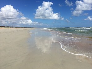 Rannalla, aurinkotuoleja, rantapyyhkeitä