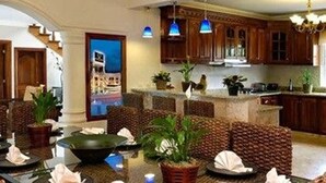 Um hall espaçoso com área de estar, um bar e uma cozinha ao fundo.